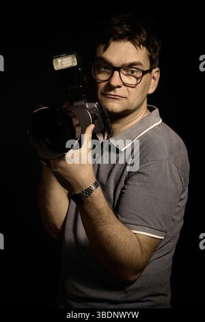 Fotografo con occhiali e camicia con fotocamera isolata Foto Stock