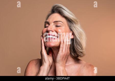 Ritratto di bellezza di una bella donna matura, concetti su cosmetici, cura della pelle e benessere. Ritratto in studio di una bella donna matura con un ey chiuso Foto Stock