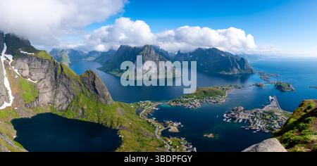 La splendida vista panoramica cattura la maestosa bellezza delle isole Lofoten in Norvegia. Le vivaci montagne verdi sorgono ripidamente dalle acque blu, mentre le soffici nuvole si spostano sopra la testa. Foto Stock