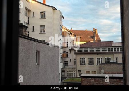 L'immagine mostra una vista da una finestra che cattura diversi edifici in un'area urbana. Gli edifici hanno stili architettonici diversi, con alcuni featu Foto Stock
