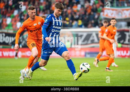 LUBIN, POLONIA - 11 APRILE 2025: Partita di calcio tra KGHM Zaglebie Lubin e Gornik Zabrze. In azione Dawid Kurminowski (L) Kryspin Szczesniak (R). Foto Stock