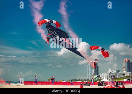 I membri dei Red Devils dell'esercito britannico issano una bandiera a goccia su Miami Beach prima dell'Hyundai Air and Sea Show il 23 maggio 2025, mentre lo U.S. Army Parachute Team funge da controllo a terra. L'Hyundai Air and Sea Show si tiene ogni anno nel Memorial Day Weekend a Miami, Florida, e ospita esibizioni di diverse squadre militari dimostrative. Ogni anno, i Red Devils dell'esercito britannico eseguono dimostrazioni congiunte con lo U.S. Army Parachute Team in varie località in tutto il mondo. (Foto dell'esercito degli Stati Uniti di SPC. Mari Kossman) Foto Stock