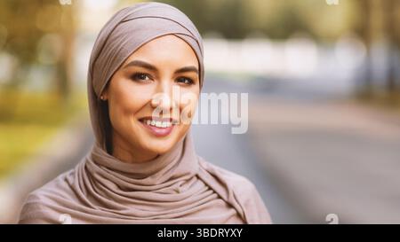 Giovane donna musulmana moderna in Hijab sorridente in posa all'aperto, Panorama Foto Stock
