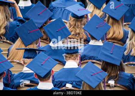 AMERICAN FORK, UT, USA – 24 MAGGIO 2025: Gli studenti che indossano cappelli di laurea si riuniscono in una scuola di American Fork, Utah, per celebrare i loro risultati. Foto Stock