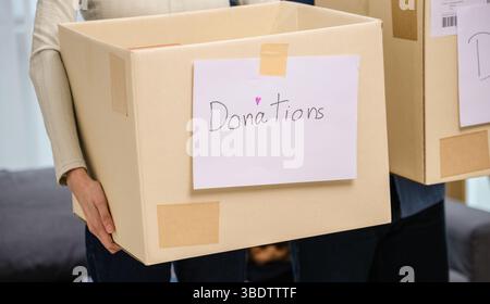 gruppo di amici che tiene in mano vestiti in una donazione box.community sostegno e donazione di beneficenza Foto Stock