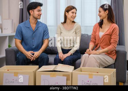 gruppo di amici che tiene in mano vestiti in una donazione box.community sostegno e donazione di beneficenza Foto Stock