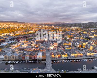 Trondheim, Norvegia, vista aerea della città al tramonto, splendidi colori degli edifici storici, nuvole scure sullo sfondo Foto Stock