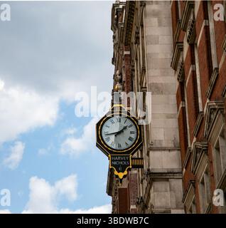 Orologio decorato di Harvey Nichols all'angolo di uno storico edificio in mattoni contro un cielo parzialmente nuvoloso Foto Stock