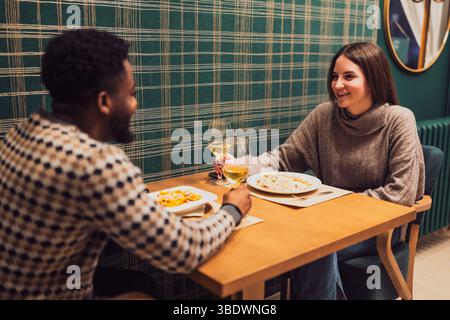 Una giovane coppia che ha una cena romantica al loro primo appuntamento. Foto Stock