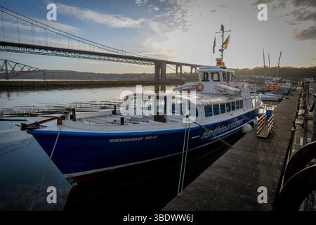 Barche nel porto sotto l'iconico ponte di Forth Road. Foto Stock