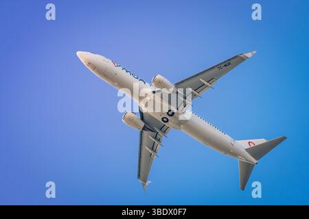 Un Boeing 737 MAX 8 commerciale viene catturato a metà volo direttamente sotto un cielo azzurro. La vista dettagliata mostra i suoi due motori, Foto Stock