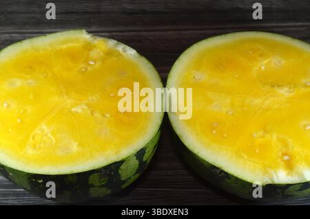 Due metà di anguria con polpa gialla, anguria (Citrullus lanatus), una specie di piante in fiore della famiglia delle Cucurbitaceae e il suo nome Foto Stock