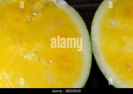 Due metà di anguria con polpa gialla, anguria (Citrullus lanatus), una specie di piante in fiore della famiglia delle Cucurbitaceae e il suo nome Foto Stock