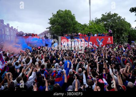 I tifosi del Crystal Palace guardano mentre la squadra passa su autobus scoperti durante la sfilata dei vincitori della fa Cup a Londra. Il Crystal Palace ha vinto la fa Cup dopo una vittoria del 1-0 sul Manchester City a Wembley. Data foto: Lunedì 26 maggio 2025. Foto Stock