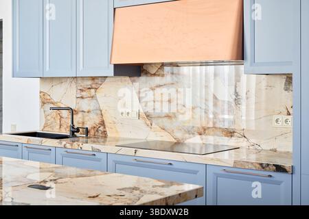 Elegante design della cucina con splendide caratteristiche in marmo e splendidi armadietti blu Foto Stock