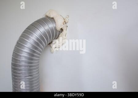 Installazione della cappa di ventilazione del bruciatore a gas con un tubo flessibile e un foro nella parete Foto Stock