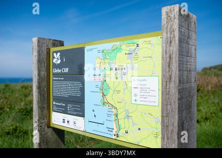 Bacheca informativa del National Trust per Glebe Cliff vicino a Tintagel, Cornovaglia, che mostra i percorsi a piedi lungo il panoramico South West Coast Path. Foto Stock