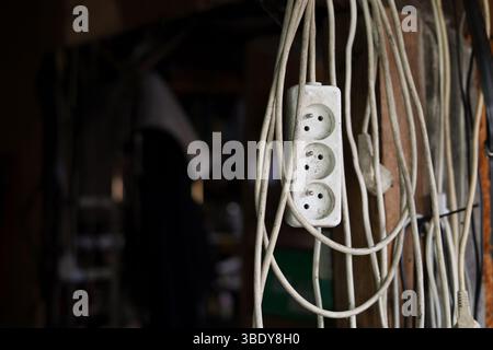 Bobina sporca delle prolunghe appese nella vecchia officina Foto Stock