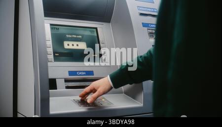 Persona non riconoscibile che immette il codice PIN sulla tastiera ATM per prelevare denaro. Messaggio di errore sul display della cassa relativo all'annullamento della transazione a causa di un codice PIN errato. Attrezzature bancarie. Primo piano. Foto Stock