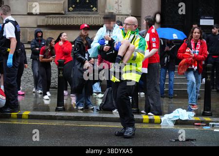 NOTA PER i REDATTORI: I volti dei bambini sono stati pixellati in quanto il Picture Desk della PA non è stato in grado di ottenere il permesso necessario per fotografare un bambino sotto i 16 anni su questioni riguardanti il loro benessere. Polizia e personale di emergenza che si occupa di un incidente vicino al Liver Building di Liverpool durante la parata dei vincitori della Premier League. Data foto: Lunedì 26 maggio 2025. Foto Stock
