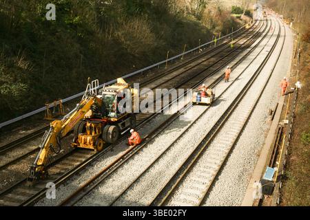 Un operaio delle ferrovie riposa sul posto durante un progetto di sostituzione della zavorra dei binari Foto Stock