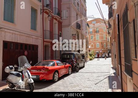 Città vecchia di Monaco con auto e moto parcheggiate sul marciapiede Foto Stock