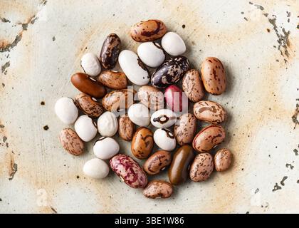 La ciotola in ceramica vista dall'alto contiene un colorato mix di legumi secchi (Phaseolus vulgaris). Legumi secchi per una cucina sana. Foto Stock