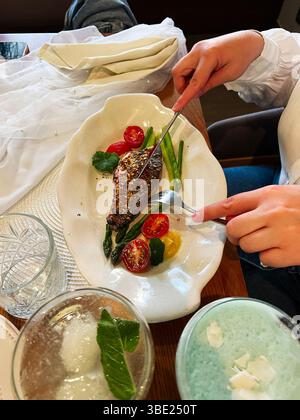 Un pasto con ingredienti freschi, elegantemente placcati e gustato in un ambiente rilassato Foto Stock