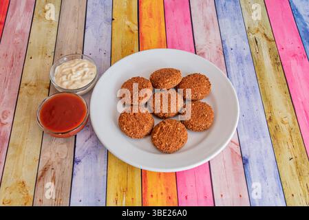 Crocchette di falafel fritte servite con una piccola salsa in un negozio di kebab Foto Stock