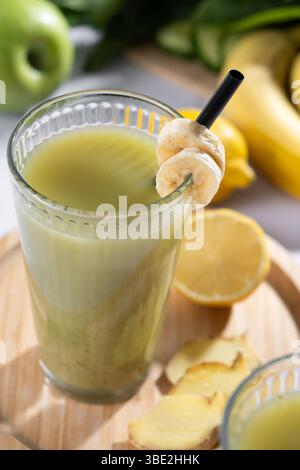Frullato verde con spinaci, banana, mela e limone su marmo bianco Foto Stock