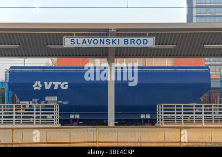 Slavonski Brod, Croazia - 22 ottobre 2024: Cartello della città presso la piattaforma principale della stazione ferroviaria, mattina presto, autunno. Foto Stock