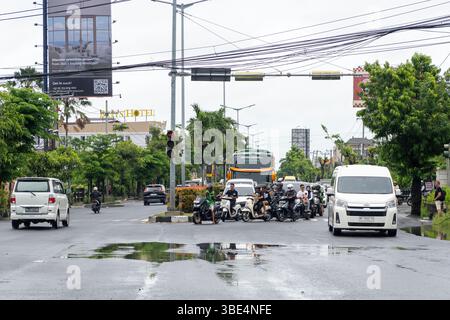 Bali, Indonesia - 25 dicembre 2024: Auto e motociclette stanno guidando lungo la strada Foto Stock