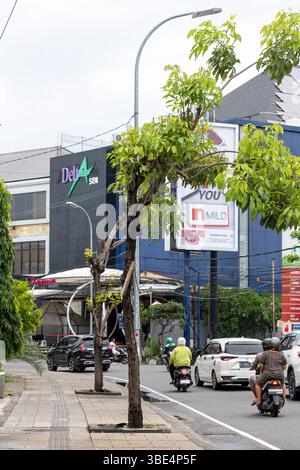 Bali, Indonesia - 25 dicembre 2024: Auto e motociclette stanno guidando lungo la strada Foto Stock