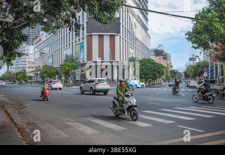 Veicoli e motociclette che guidano per strada. Paesaggio urbano della città di Nha Trang con motociclisti e auto su strade trafficate. Foto di viaggio, editori Foto Stock