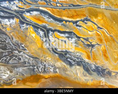 Dall'alto, un drone aereo cattura gli intricati motivi di texture astratte della natura, mostrando un'affascinante miscela di tonalità gialle e grigie che c Foto Stock