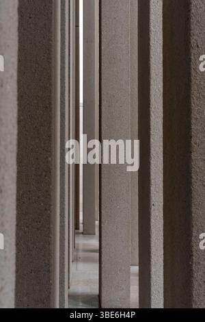 Uno stretto passaggio con pareti in cemento testurizzato incanala la luce del giorno all'interno del complesso Abrahamic Family House di Abu Dhabi a simboleggiare l'unità. Foto Stock