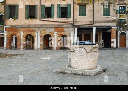 Campo del Ghetto nuovo con una testa di pozzo del XV secolo e la galleria del Banco Rosso, il più antico pedone ebraico (1516), ora museo, Venezia, Italia Foto Stock