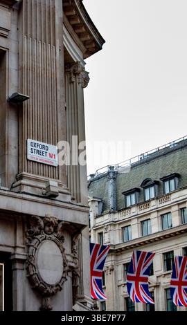 Architettura classica in Oxford Street a Londra con bandiere Union Jack. Iconico quartiere dello shopping. Foto Stock