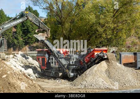 Un frantumatore a impatto in azione, che frantuma grossi frammenti di roccia in pezzi più piccoli Foto Stock
