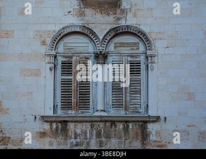 Due finestre ad arco bifora in una facciata storica nel foro di Trg, la piazza principale di Pola, istria, Croazia. Veneziano con influenze gotiche e rinascimentali Foto Stock