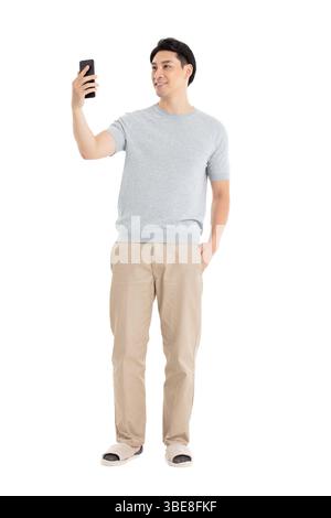 Un giovane che fissa il suo schermo del telefono, assolutamente entusiasta con il braccio alzato in alto Foto Stock