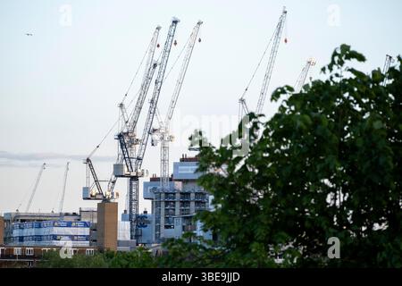 Gru operanti in un cantiere di costruzione/sviluppo a Bermondsey il 5 maggio 2025 a Londra, Regno Unito. Foto Stock