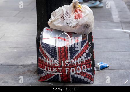 La borsa Marks & Spencers Food Hall viene utilizzata per contenere i rifiuti sul marciapiede il 7 maggio 2025 a Londra, Regno Unito. Marks & Spencer Group plc, nota anche come M&S, è un'importante multinazionale britannica specializzata nella vendita di abbigliamento, prodotti per la casa e prodotti alimentari di lusso. Foto Stock