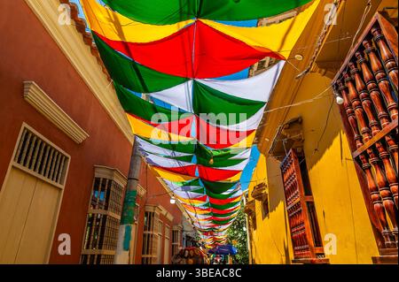 Una vista su una strada secondaria coperta da baldacchino nel quartiere Getsemani di Cartagena, Columbia, in primavera Foto Stock