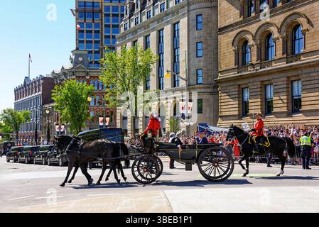 Ottawa, Canada - 27 maggio 2025: La Royal Canadian Mounted Police guida una carrozza che trasporta il re Carlo III e la regina Camilla durante la loro visita a Ottawa. Il primo ministro Mark Carney ha invitato il re a tenere il discorso sul trono per celebrare la sessione di apertura del parlamento canadese. C'era un'enorme folla di persone che aspettavano di vedere il re. Foto Stock