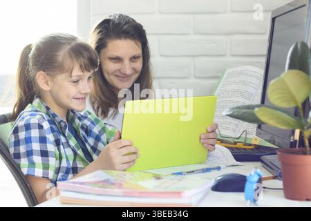 Mamma e figlia comunicano tramite video utilizzando un tablet Foto Stock