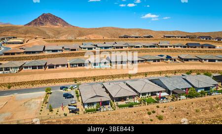 Sviluppo aereo delle abitazioni suburbane del deserto con sfondo di montagna Fly Over Foto Stock