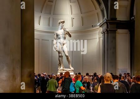 Folle di persone che guardano il David di Michelangelo, una scultura in marmo esposta alla Galleria dell'Accademia di Firenze, Firenze, Italia Foto Stock