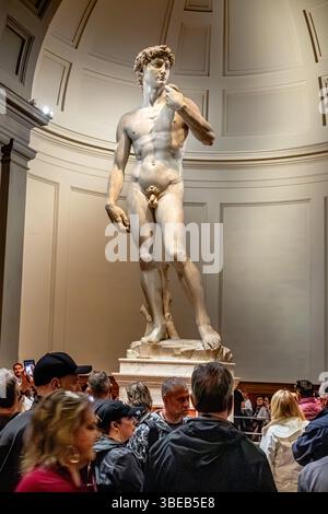 Folle di persone che guardano il David di Michelangelo, una scultura in marmo esposta alla Galleria dell'Accademia di Firenze, Firenze, Italia Foto Stock