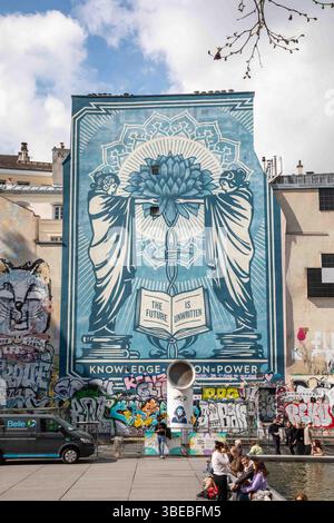 Conoscenza + azione = potenza. Grandi graffiti murali di Shepard Fairey a Place Igor Stravinsky nel quartiere Marais di Parigi, Francia. Foto Stock
